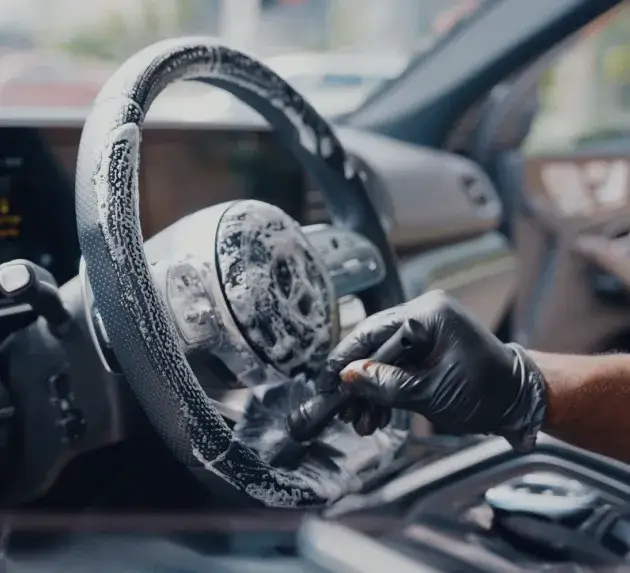 Fully foamed steering wheel getting a deep cleaning with a detail brush